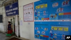 A staff member wearing mask walks out of a special ward set aside for possible COVID-19 patients at a government run hospital in Ahmedabad, India, March 6, 2020.