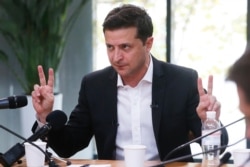 FILE - Ukrainian President Volodymyr Zelenskiy speaks during talks with journalists in Kyiv, Ukraine, Oct. 10, 2019. The Ukrainian leader held an all-day “media marathon” in a Kyiv food court amid growing questions about his actions as president.