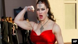 FILE - In this Nov. 16, 2003 file photo, Joanie Laurer, former pro wrestler known as Chyna, flexes her bicep as she arrives at the 31st annual American Music Awards, in Los Angeles.