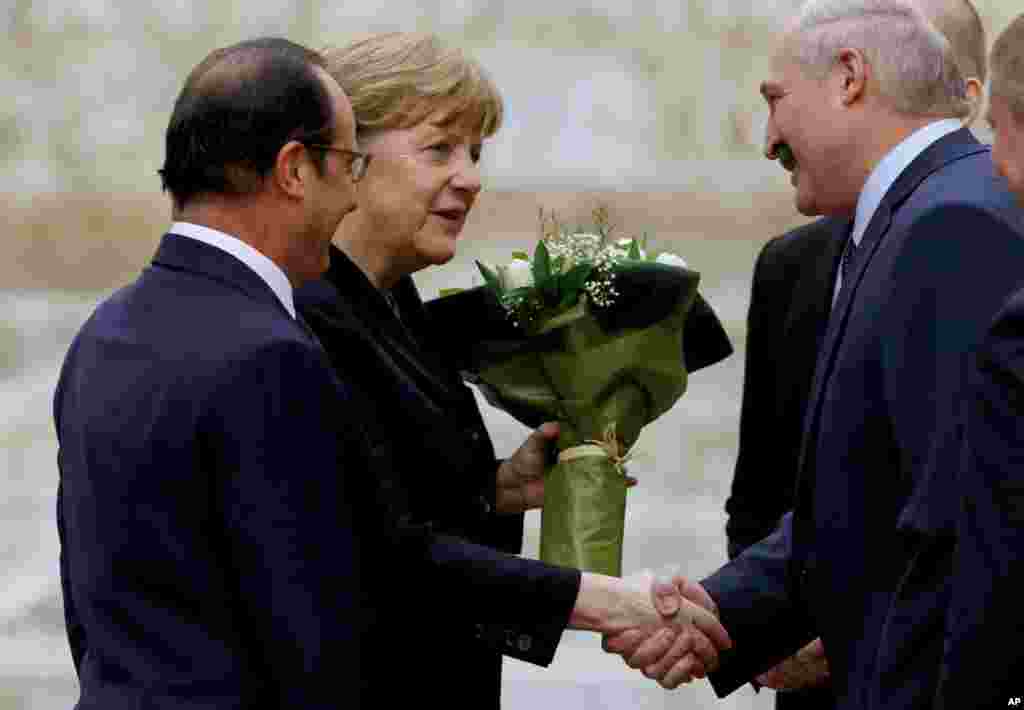 Presiden Belarus, Alexander Lukashenko, menyapa Kanselir Jerman Angela Merkel (tengah) dan Presiden Perancis Francois Hollande (kiri) di Minsk (11/2). (AP/Sergei Grits)