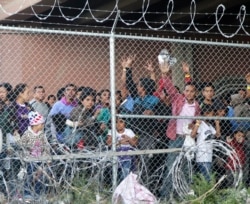 Central American migrants wait for food in a pen erected by U.S. Customs and Border Protection to process a surge of migrant families and unaccompanied minors in El Paso, Texas, March 27, 2019.