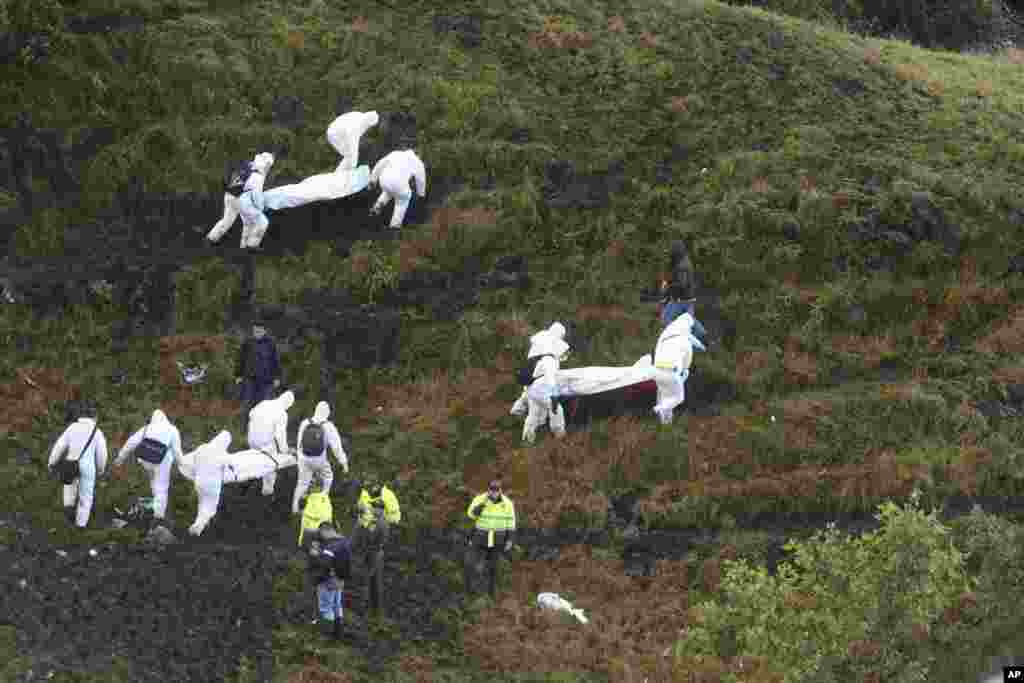 Rescue workers carry the bodies of victims of an airplane that crashed in La Union, a mountainous area outside Medellin, Colombia, Nov. 29, 2016. The plane was carrying the Brazilian first division soccer club Chapecoense team that was on it's way for a Copa Sudamericana final match against Colombia's Atletico Nacional. 