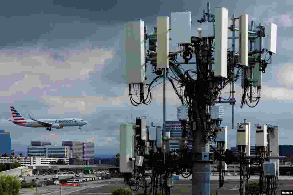 An American Airlines commercial aircraft flies past a cell phone tower as it approaches to land at John Wayne Airport in Santa Ana, California, Jan. 18, 2022.