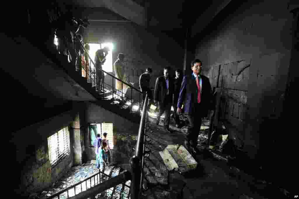 Bangladeshi officials inspect a garment-factory where a fire killed more than 110 people Saturday on the outskirts of Dhaka, Bangladesh, November 26, 2012.