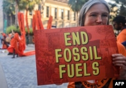 Activists protest against fossil fuels on the sidelines of the COP28 United Nations climate summit in Dubai on December 5, 2023. (Photo by Karim SAHIB / AFP)