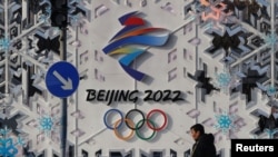 A man walks past an installation of Beijing 2022 ahead of the Beijing 2022 Winter Olympics in Beijing, China January 25, 2022. REUTERS/Tyrone Siu