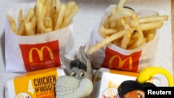 Dos Happy Meals de McDonald's con relojes de juguete diseñados con los personajes Asno y el Gato con Botas de la película "Shrek Forever After" se muestran en Los Ángeles.