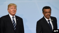 (L to R) French President Emmanuel Macron , US President Donald Trump and Director-General of the World Health Organization (WHO) Tedros Adhanom leave after posing a photo on the first day of the G20 summit in Hamburg, northern Germany, on July 7, 2017.