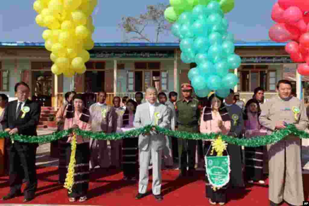 Yohei Sasakawa, centre, Japan Goodwill Ambassador for the Welfare of the National Races in Myanmar, Chairman of the Nippon Foundation, Mikio Numata, left, Japan ambassador to Myanmar, and Sao Aung Myat, right, Shan State chief minister, cut ribbon during