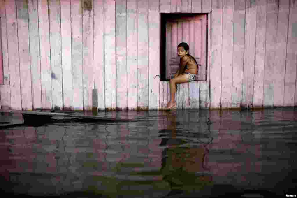 A child is seen on a street flooded by the rising Rio Solimoes, one of the two main branches of the Amazon River, in Anama, Amazonas state, Brazil.