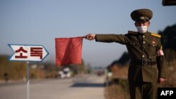 Arhiva - Pripadnik sjevernokorejske javne bezbjednosti zaustavlja taksi radi dezinfekcije, u sklopu napora protiv širenja Covida-19, na putu na ulazu u Vosan, pokrajina Kangvon, Sjeverna Koreja, 29. oktobra 2020