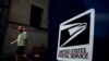 A man walks by a United States Postal Service mailbox in downtown Washington, Aug. 19, 2020. 