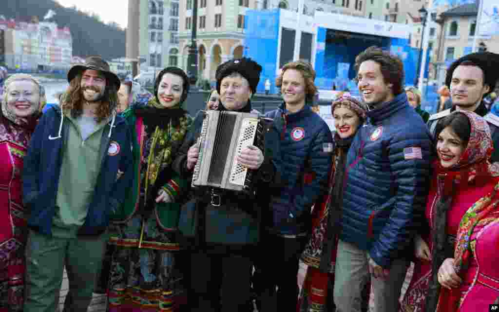 Members of the U.S. freestyle skiing team pose with members of a Cossack dancing chorus dressed in traditional costumes in Rosa Khutor, Feb. 6, 2014.