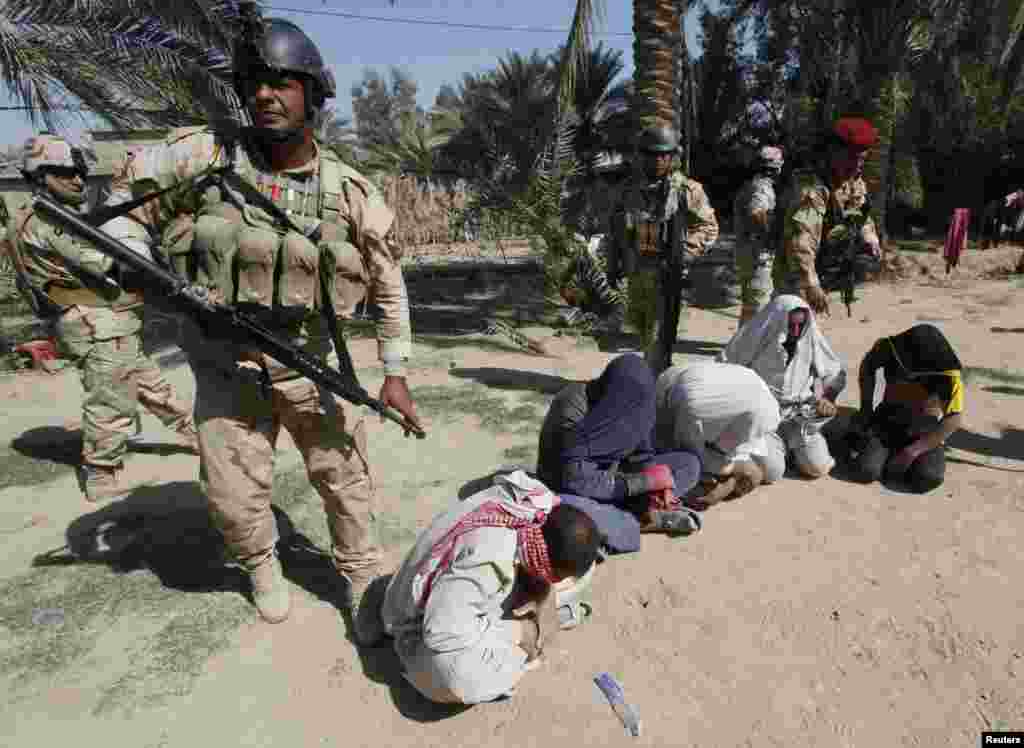 Iraqi soldiers arrest suspected militants during a raid and weapons search operation in North Babil province, Oct. 27, 2013.