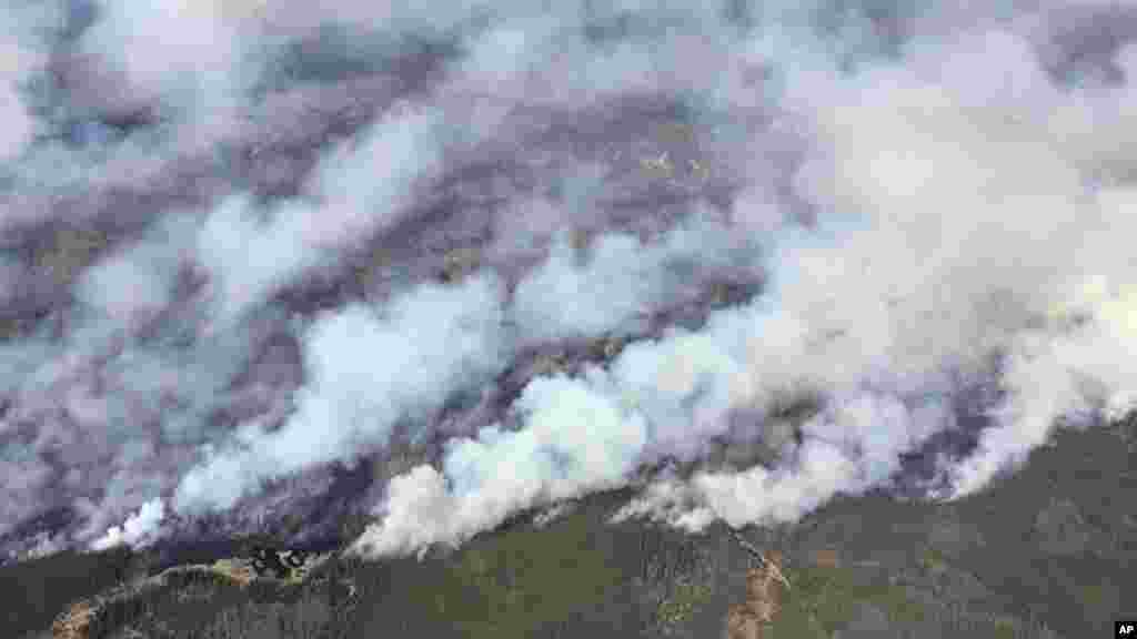 Une vue aérienne de l'hélicoptère du premier ministre de l'Alberta Rachel Notley montre la fumée qui fait ravage dans le forêt de Fort McMurray, Alberta, le 4 mai 2016.