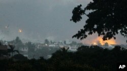 Fire and smoke billows from the Akouedo military camp in Abidjan on April 4, 2011, after UN helicopters fired on troops loyal to Laurent Gbagbo