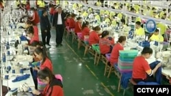 中國新疆和田一所職業教育訓練中心的穆斯林學員在服裝廠裡工作。(2019年1月9日)