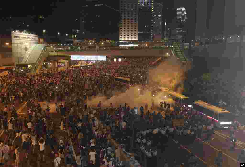 Riot police use tear gas against protesters after thousands of people blocked a main road at the financial central district in Hong Kong.