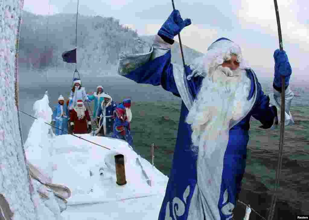 Para anggota sebuah klub yacht berpakaian seperti Ded Moroz (Sinterklas Rusia) berlayar dengan yacht di sungai Yenisei di kota Krasnoyarsk, Siberia-Rusia.