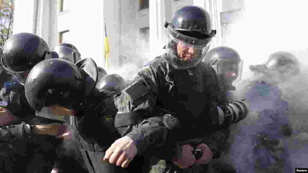 Interior Ministry members stand guard in formation during clashes between radical protesters with law enforcement members during a rally near the parliament building in Kyiv, Oct. 14, 2014.