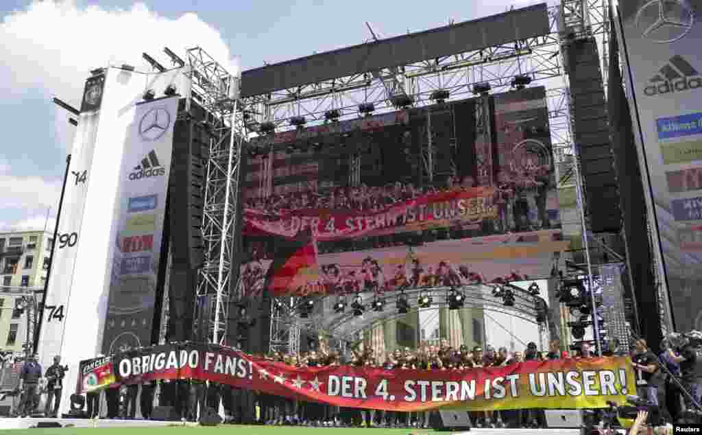 German soccer players wave to their supporters from a stage during celebrations to mark the team's 2014 Brazil World Cup victory, at the Fan Mile public viewing zone in Berlin, July 15, 2014.