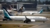 Anggota kru berbincang dekat pesawat Boeing 737 MAX 8 yang dioperasikan Shanghai Airlines di landasan Bandara Hongqiao di Shanghai, China, 12 Maret 2019. 