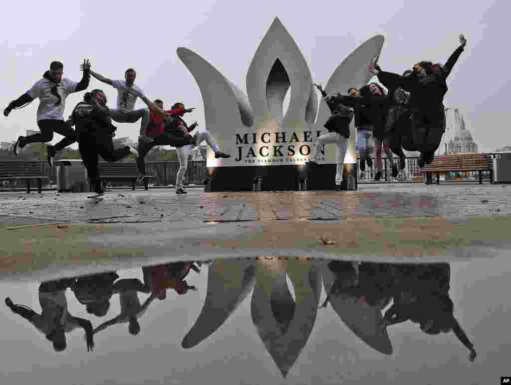 Fans of the former King of Pop Michael Jackson pose for photographers to celebrate Jackson's Diamond Birthday Celebration with the installation of a giant 13-foot jeweled crown at London's iconic Southbank.