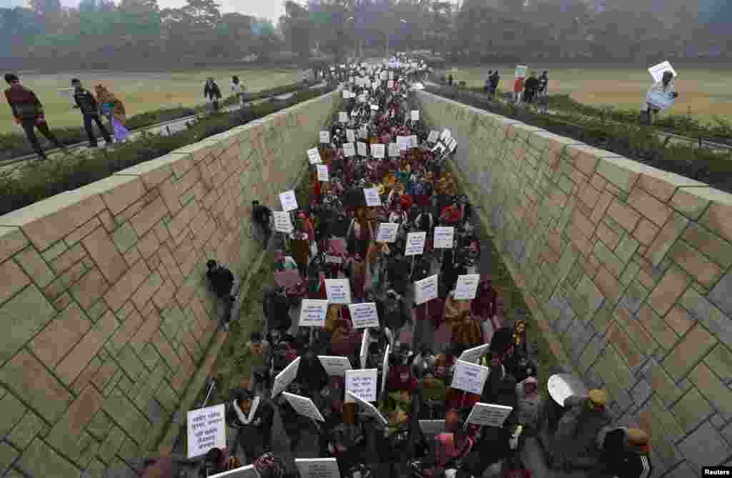 Women carrying placards enter Raj Ghat to attend a prayer ceremony for a rape victim after a rally organized by Delhi Chief Minister Sheila Dikshit (unseen), New Delhi, India, January 2, 2013.