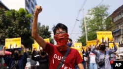 Anti-coup protesters gesture during a march in Yangon, Myanmar, Friday, March 26, 2021. Protesters against last month's military takeover in Myanmar returned to the streets in large numbers Thursday, a day after staging a "silence strike" in which…