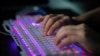 ARCHIVO - Un miembro de un grupo de piratas informáticos usa su computadora en la oficina del grupo en Dongguan, China, el 4 de agosto de 2020. 
