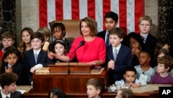 House Speaker Nancy Pelosi of California, surrounded by her grandchildren and other children, pounds the gavel at the Capitol in Washington, Thursday, Jan. 3, 2019. (AP Photo/Carolyn Kaster)