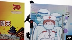 Workers put up government propaganda to fight against the viral outbreak in Beijing, China, Feb. 20, 2020. 
