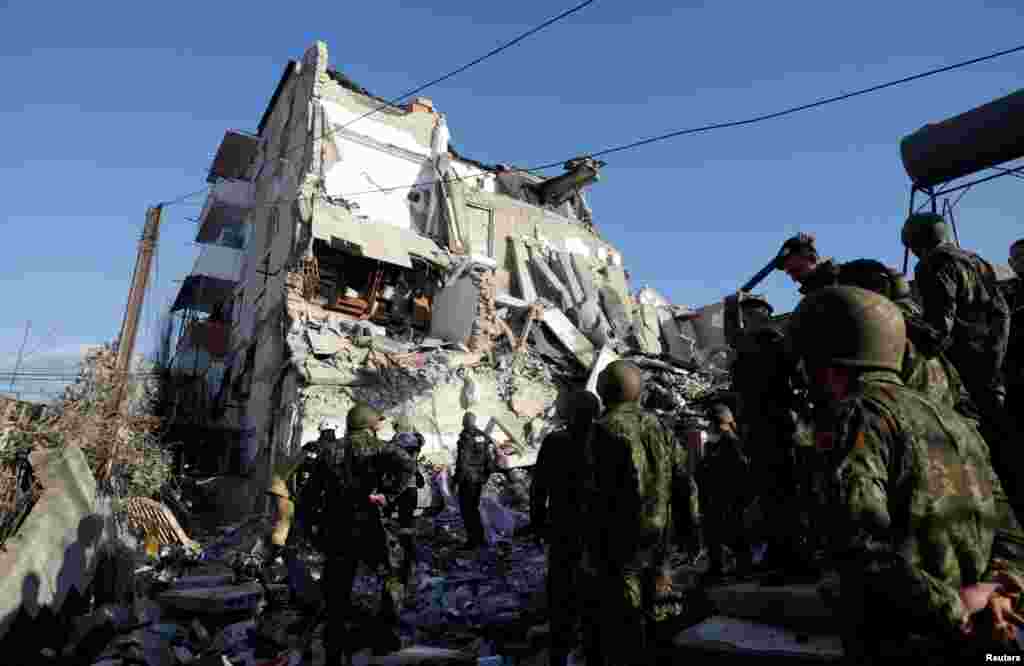 Emergency personnel work near a damaged building in Thumane, after an earthquake shook Albania, Nov. 26, 2019.