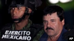 FILE - Mexican drug lord Joaquin "El Chapo" Guzman, right, is escorted by soldiers and marines to a waiting helicopter, at a federal hangar in Mexico City, Jan. 8, 2016. 