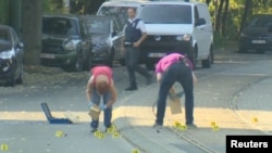 A bomb disposal expert is seen searching a car in the Brussels' neighborhood of Woluwe St. Pierre, June 30, 2018. (RTL Television)