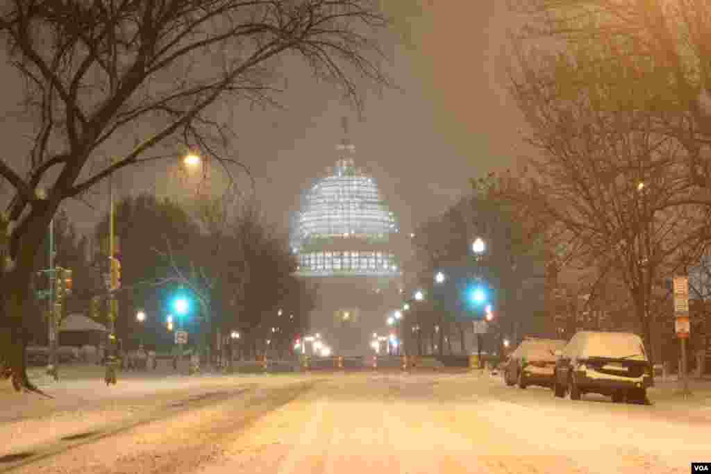 The illuminated dome of the US Capitol could be seen through the wind-blown snow at the intersection of 3rd and E. Capitol streets in Northeast Washington (P. Datcher/VOA)