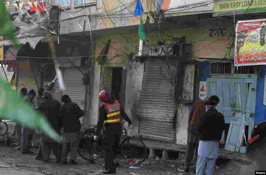 Security officials and rescue workers survey the site of a suicide blast in Rawalpindi, Pakistan, Jan. 20, 2014.