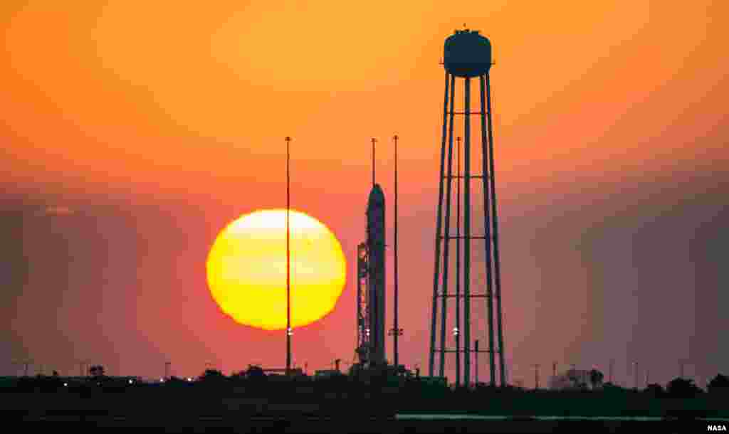 The Orbital Sciences Corporation Antares rocket, with the Cygnus spacecraft onboard, is seen on launch Pad-0A during sunrise, at NASA Wallops Flight Facility in Virginia, Oct. 26, 2014.