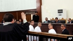 Produser Al-Jazeera Bahasa Inggris Baher Mohamed (tengah, kiri), penjabat kepala biro Kairo Mohammed Fahmy (tengah) dan koresponden Peter Greste dalam sidang di Kairo. (Foto: Dok)
